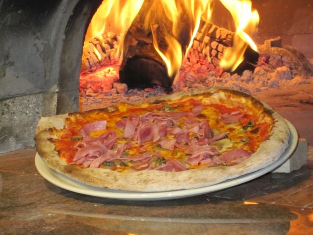 Pizza devant le four à bois